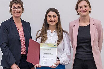 Kongresspräsidentinnen des diesjährigen DGE-Kongresses Prof. Dr. Ute Weisz und Prof. Dr. Ute Nöthlings überreichen den Posterpreis an Hande Gagali  Fotonachweis: Copyright Thomas Hauss