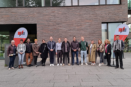 Alumni stehen vor dem Gebäude der DHBW Heilbronn
