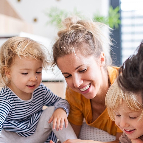 Auf dem Foto ist eine Familie mit einem Mann, einer Frau und zwei Kindern zu sehen.