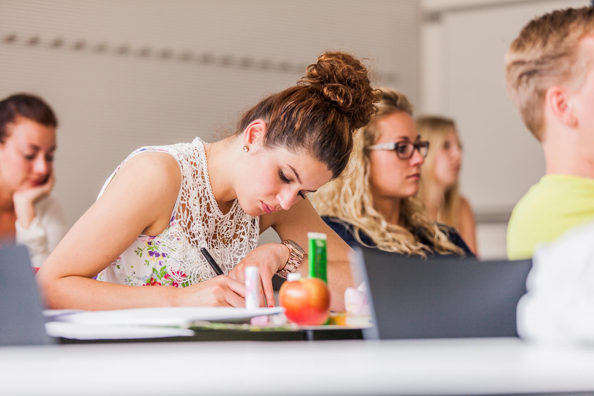 Das Foto zeigt fünf Studierende während der Vorlesung. 