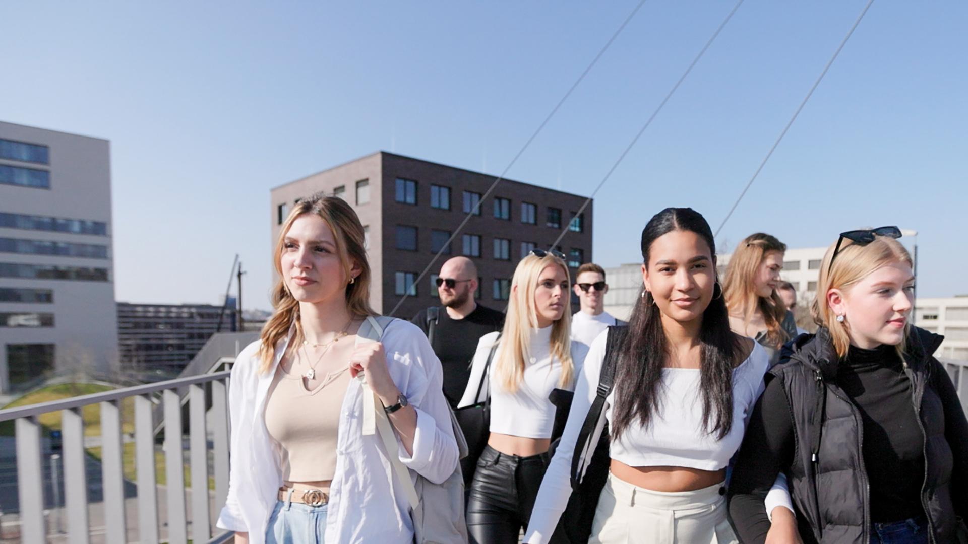 Gruppe von Studierenden auf der Campusbrücke  Auf dem Foto ist eine Gruppe von Studierenden auf der Campusbrücke auf dem Bildungscampus Heilbronn zu sehen.