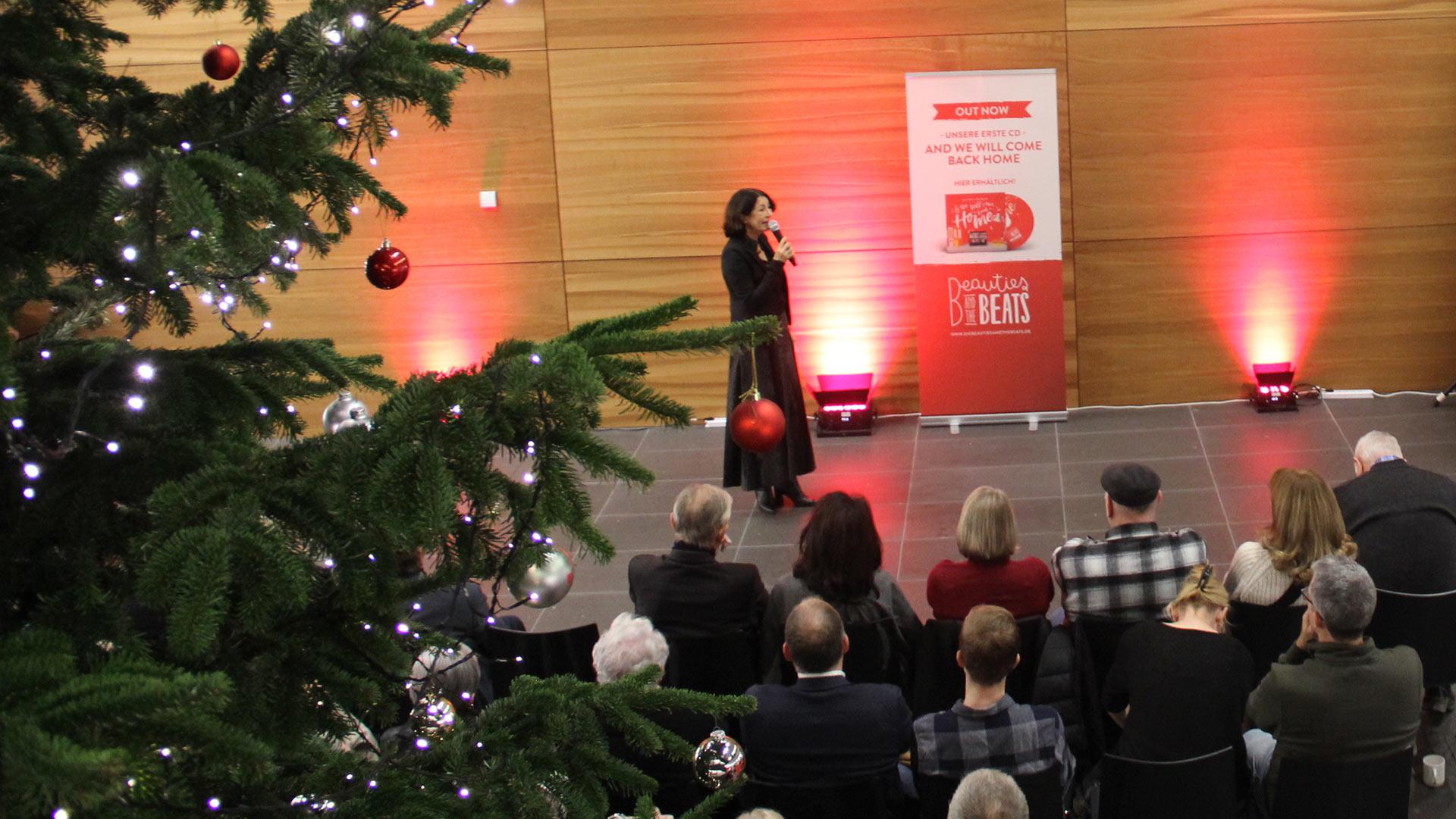 Auf dem Foto sieht man Prof. Dr. Nicole Graf, die vor dem Publikum des Adventskonzerts steht und in ein Mikrofon spricht.