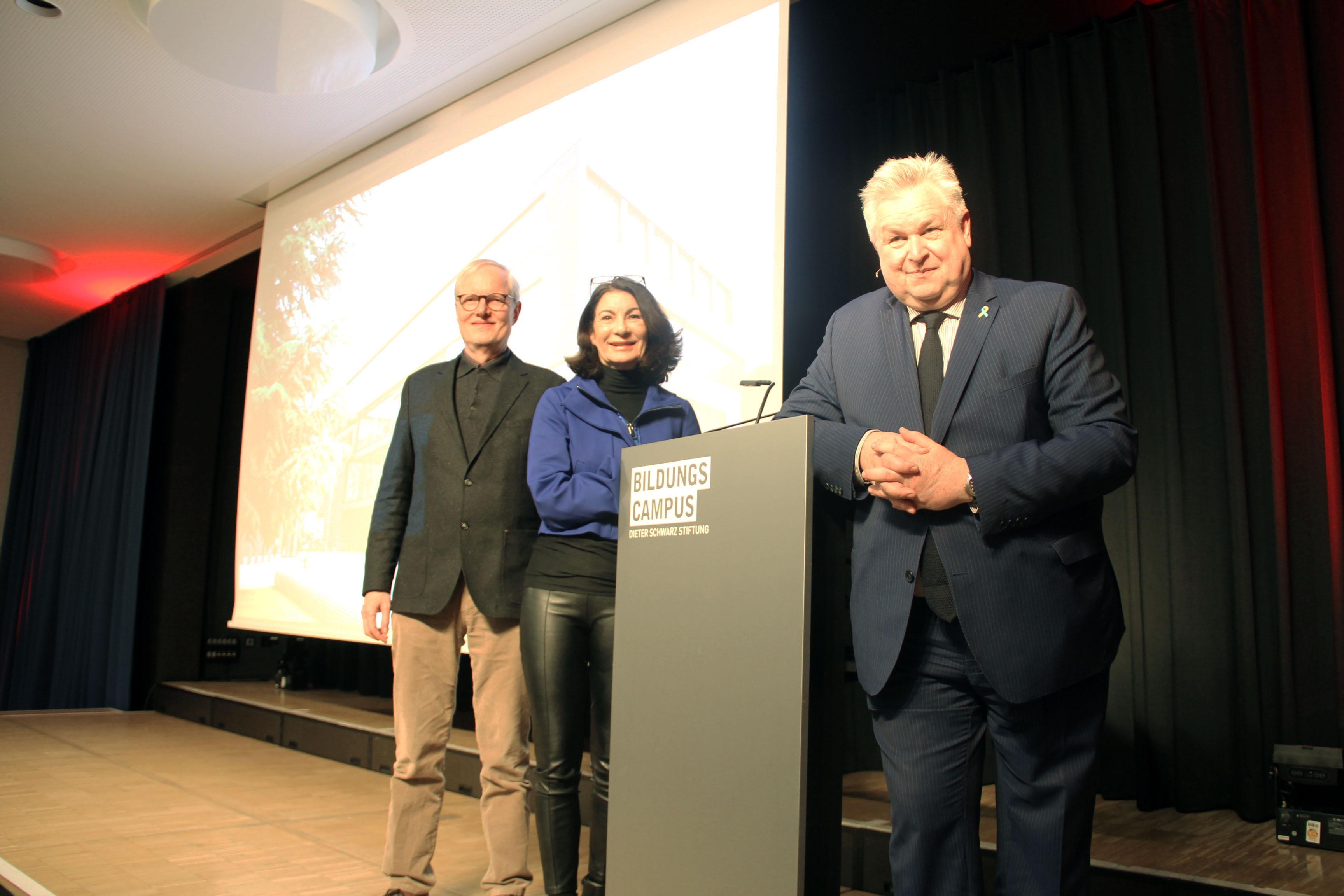 Hinter dem Pult stehen von links nach rechts Peter Hawighorst, Leiter der Volkshochschule Heilbronn, Rektorin Prof. Dr. Nicole Graf und MdB Michael Georg Link 