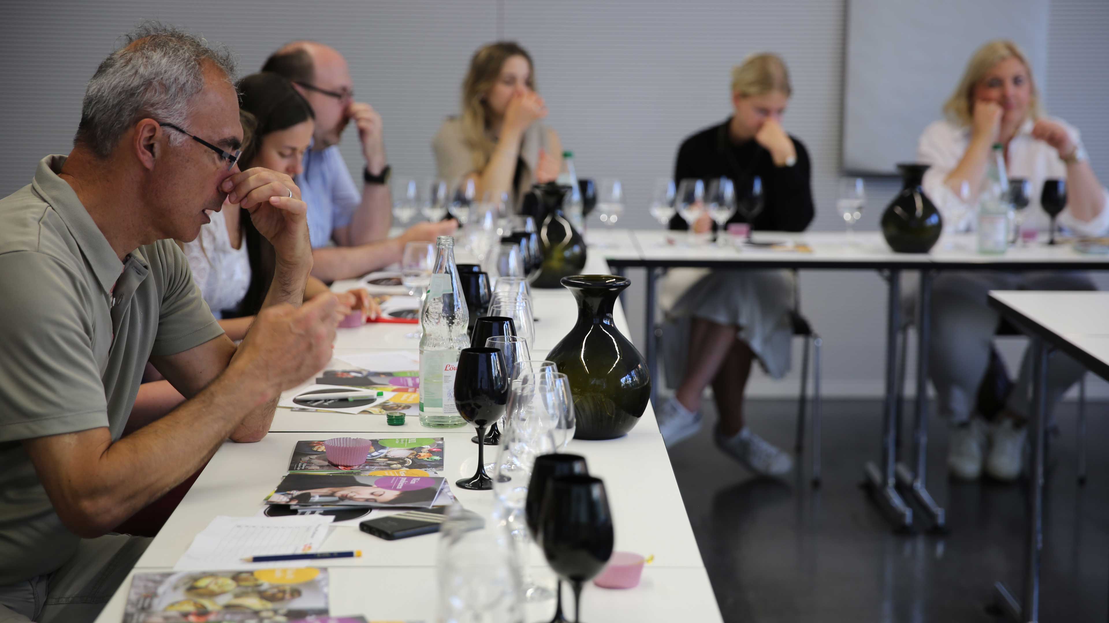 Die Teilnehmer*innen riechen am Wein und probieren diesen aus verschiedenen Gläsern. 
