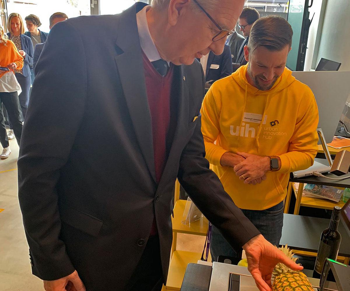 Erster Bürgermeister der Stadt Heilbronn Martin Diepgen testet die Produkterkennung bei der KI-gestützten Waage.