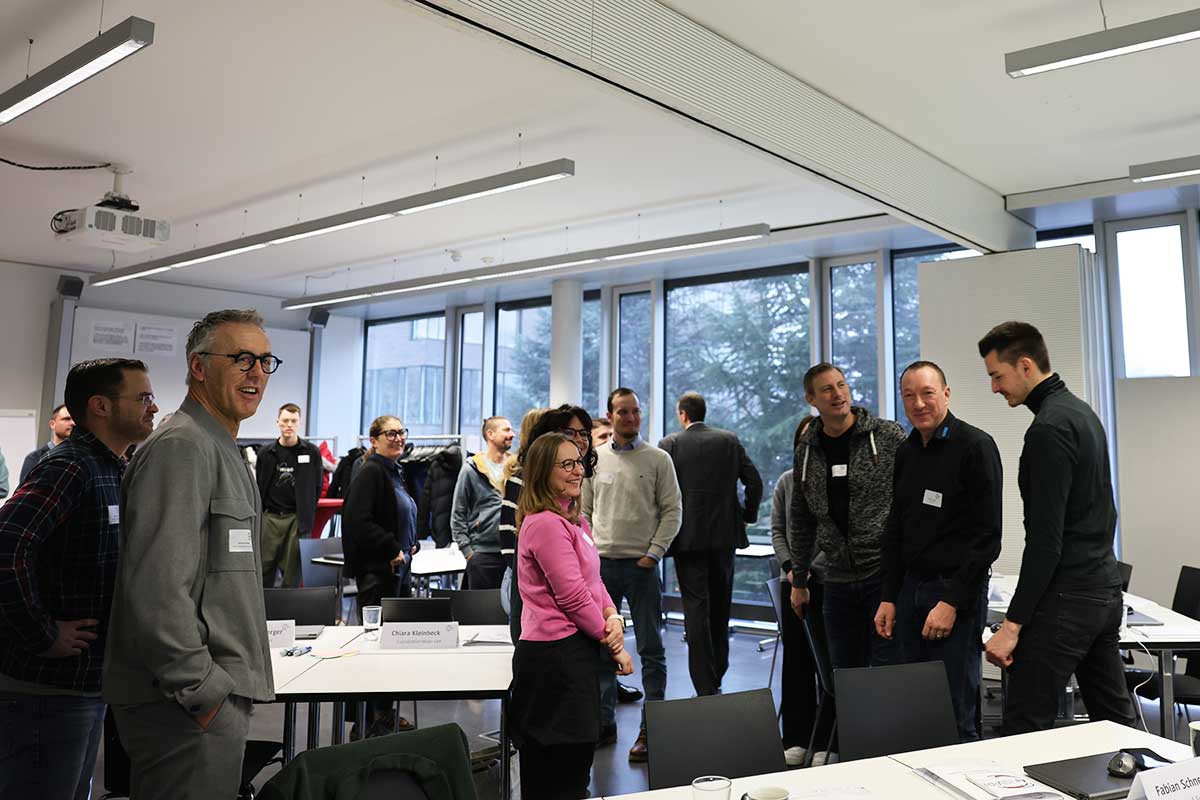 Workshop animiert - die Teilnehmer stehen auf und stellen sich in verschiedenen Gruppen auf - entsprechend ihrer Antworten auf Fragen nach KI-Kompetenz oder Technikaffinität. 