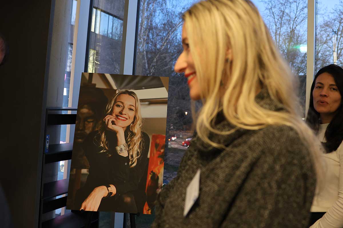 Role Model, strategische Projektleitung von WoMent und Gleichstellungsbeauftragte der DHBW Heilbronn Prof. Dr. Yvonne Zajontz vor ihrem Portrait - zu Hause inmitten ihrer eigenen Kunst. 